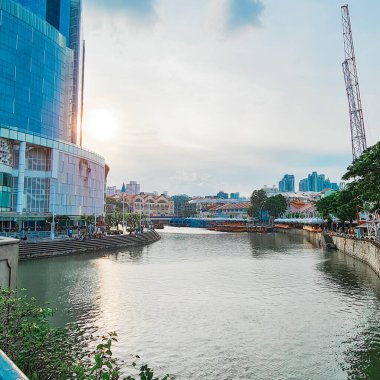 Singapur Ocak 01 2023: Gün batımında Clarke Rıhtımı yakınlarındaki Singapur Nehri, Clarke Quay Central Mall boyunca bir nehir teknesi, gezinti ve uzak diyarlardaki Peranakan tarzı dükkanlar