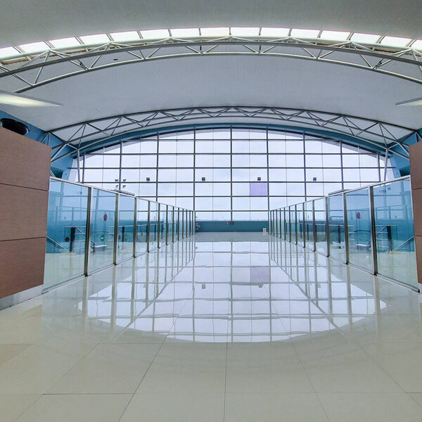 Jakarta Dec 31 2022: Huge glass window at Terminal 3 Soekarno Hatta International Airport Departure Gates facing the runway. curved roof with space frame steel structure, glass barrier railing