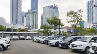Jakarta Endonezya - 22 Ağustos 2023: Şehir merkezinin ortasında ağaçlar, gökdelen binaları ve birçok arabanın bulunduğu güneşli bir gün