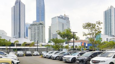 Jakarta Endonezya - 22 Ağustos 2023: Şehir merkezinin ortasında ağaçlar, gökdelen binaları ve birçok arabanın bulunduğu güneşli bir gün