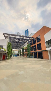 Cakarta Endonezya 22 Ağustos 2023: Parlak güneşli bir günde bir Satrio Outdoor alışveriş merkezinin kaplanmış yolu ve bir dizi restoran, dükkan ve kafe, renkli fenerler