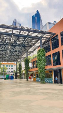 Cakarta Endonezya 22 Ağustos 2023: Parlak güneşli bir günde bir Satrio Outdoor alışveriş merkezinin kaplanmış yolu ve bir dizi restoran, dükkan ve kafe, renkli fenerler