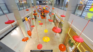 Penang Malezya 12 Ocak 2024: Bir alışveriş merkezi koridorunda Çin Yeni Yıl Şenlikleri. Tavandan sarkan renkli fenerler. Gurney Paragon Alışveriş Merkezi. Lüks İsviçre Saat Dükkanları