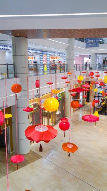 Penang Malezya 12 Ocak 2024: Bir alışveriş merkezi koridorunda Çin Yeni Yıl Şenlikleri. Tavandan sarkan renkli fenerler. Gurney Paragon Alışveriş Merkezi. Lüks İsviçre Saat Dükkanları