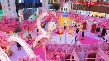 Penang Malezya 15 Ocak 2024: Bir alışveriş merkezi koridorunda Çin Yeni Yıl Şenlikleri. Tavandan sarkan fenerler. Gurney Plaza Alışveriş Merkezi. Pembe ejderha ve kiraz ağaçları.