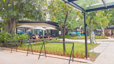 Jakarta Aug 22 2023: Şehir Ormanı Cipete, birçok restoranı olan bir halk parkı. Ağaçlar güzel bir gölge sağlıyor. Beton ve çakıl döşeme, açık masa ve sandalyeler, yemek ve takılma deneyimi