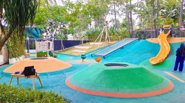 Jakarta Endonezya 22 Ağustos 2023: Urban Forest Cipete 'de açık hava oyun alanı, restoranları olan halk parkı. Kaygan yamaçlar, tepecikler, kauçuk döşemeler, yemyeşil peyzajlar ve gölge ağaçlar. oyun oynayan çocuklar