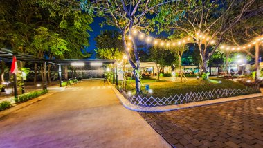Jakarta 22 Ağustos 2023: Geceleri Şehir Ormanı Cipete 'deki restoranlar, güzel ışıklandırma, perili ışıklar, kaldırım taşı patikası, verimli peyzaj, açık hava piknik masaları. Parkta yemek yemek.