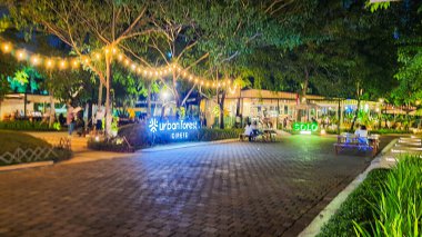 Jakarta 22 Ağustos 2023: Geceleri Şehir Ormanı Cipete 'deki restoranlar, güzel ışıklandırma, perili ışıklar, kaldırım taşı patikası, verimli peyzaj, açık hava piknik masaları. Parkta yemek yemek.