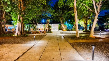 Jakarta 22 Ağustos 2023: Geceleri Şehir Ormanı Cipete 'deki restoranlar, güzel ışıklandırma, perili ışıklar, kaldırım taşı patikası, verimli peyzaj, açık hava piknik masaları. Parkta yemek yemek.