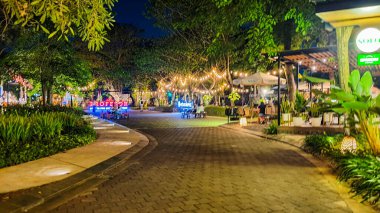 Jakarta 22 Ağustos 2023: Geceleri Şehir Ormanı Cipete 'deki restoranlar, güzel ışıklandırma, perili ışıklar, kaldırım taşı patikası, verimli peyzaj, açık hava piknik masaları. Parkta yemek yemek.