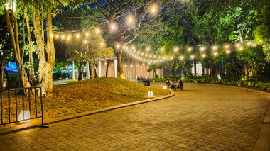 Jakarta 22 Ağustos 2023: Geceleri Şehir Ormanı Cipete 'deki restoranlar, güzel ışıklandırma, perili ışıklar, kaldırım taşı patikası, verimli peyzaj, açık hava piknik masaları. Parkta yemek yemek.