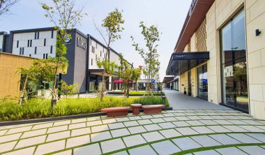 Jakarta Nov 01 2023: Arkasında bazı mağaza binaları ve Endonezya Tasarım Bölgesi PIK2 AVM 'de güzel tropikal peyzajı olan bir bahçede beton geçit.