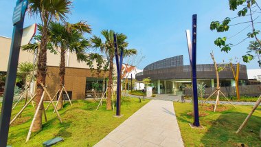 Jakarta Nov 01 2023: Gri kurdele şekilli kafeterya binası delinmiş ve cam cepheli. Benzersiz kıvrımlı kıvrımlı şekil. İkonik. Mavi gökyüzü, bereketli peyzaj.