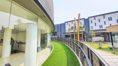 Jakarta Nov 01 2023: Endonezya Tasarım Bölgesi PIK2 'deki bir binanın önündeki yapay çimlerle kaplı kıvrımlı yürüyüş rampası