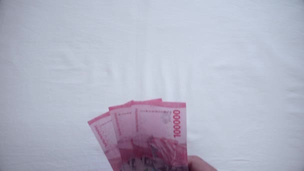 一个商人用10万印尼盾的钞票付了一笔钱 — 图库视频影像