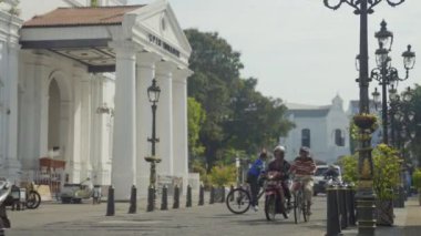 Semarang, Endonezya, 13 Aralık 2023 - Yaşlı bir büyükbaba klasik bisikletini eski tarihi şehirde sürüyor, Hollanda 'daki bir koloni kilise binası olan Blenduk Kilisesi' nin önünden geçiyor.