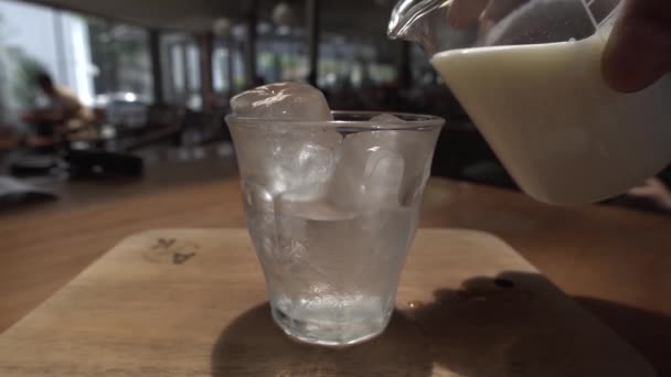 玻璃杯中的冰块首先倒入焦糖牛奶 然后加入黑咖啡 形成一种令人愉快的焦糖拿铁咖啡饮料 — 图库视频影像