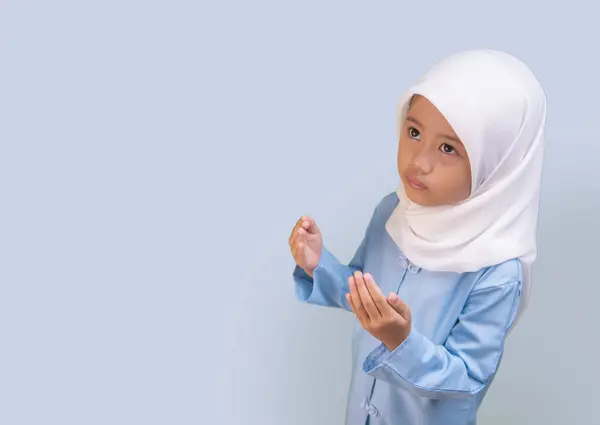 Müslüman küçük bir kız Tanrı 'ya olan bağlılığının bir sembolü olarak yukarı doğru dua ediyor..