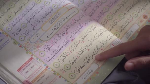 关闭彩色编码的 古兰经 以便于阅读和记忆 正在用手指阅读和翻开这一页 — 图库视频影像