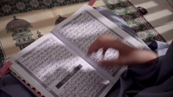Woman Reads Quran Gently Turning Its Pages Illuminated Dramatic Sunlight — Stock Video