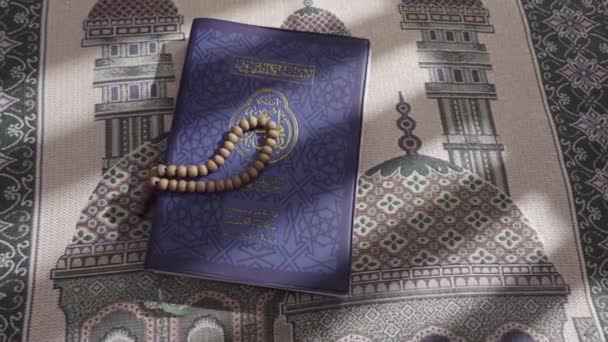 Деревянные Четки Лежат Поверх Корана Который Лежит Молитвенном Коврике — стоковое видео