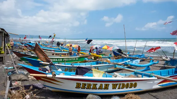 Yogyakarta, Endonezya, 24 Şubat 2024 Endonezya balıkçı köyü. Olumsuz hava koşulları yüzünden kıyıya vuran balıkçı tekneleri denize açılmalarını engelliyor..