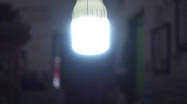 Bir el soket tutucusundan lambayı çıkarır. Oturma odasındaki ışığı kapatıyorum. Enerji tasarrufu LED ampulleri