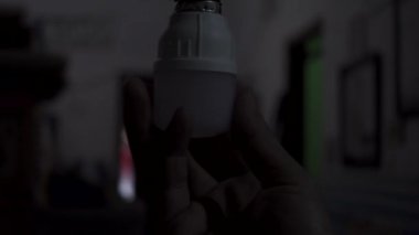 Bir el lambayı soket tutacağına vidalıyor. Oturma odasının ışığını açıyorum. Enerji tasarrufu LED ampulleri