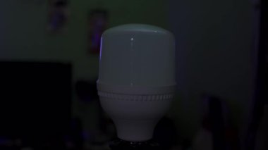 Bir insan eli, elektrik prizinde kurşun bir ampulü çevirir. Odadaki ampulü yakıyorum.