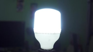 Bir insan eli, elektrik prizinde kurşun bir ampulü çevirir. Odadaki ampulü kapatıyorum.