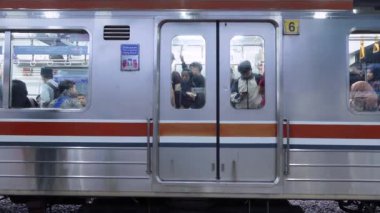 Jakarta, Endonezya, Ağustos 01, 2024 - banliyö treni kapıları kapalı. Banliyö treni istasyondan ayrılıyor..