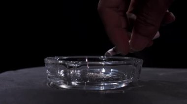 Sigara küllerini kül tablasına atar. Sigara içmek tehlikelidir. Sağlık videosu konsepti.