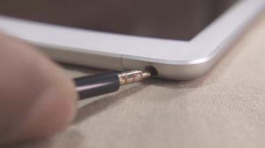 Ses kablosu, Tablet 'in kulaklığına takılı. Bağlantı ve teknoloji kavramları gösteriliyor.
