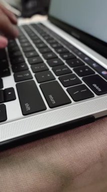 Bir dizüstü bilgisayarda yazı yazan ve Enter tuşuna (geri dönüş anahtarı) basan, çevrimiçi etkinliği veya veri girdisini sembolize eden erkeklerin yakın plan görüntüsü