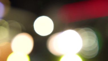 Şehir turunun Bokeh arka planı. Şehir merkezindeki işlek caddede bulanık farlar ve hareket halindeki arabalar..