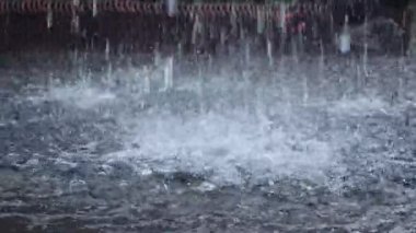 Şiddetli sağanak yağış ve su evlerin oluklarından hızla akıyor, yoğun yağış ve akıntıyı gösteriyor..