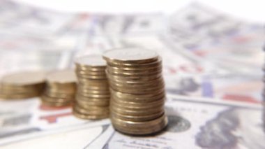 Dağınık dolarların üstüne düzgünce düzenlenmiş bir yığın para, zenginliği, tasarrufu ve finansal büyümeyi simgeliyor..