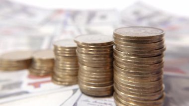 Madeni paraların istiflenmesi finansal büyümeyi ve ekonomik refahı sembolize eder, dolar banknotları üzerine kurulur, zenginlik ve başarıyı çağrıştırır.