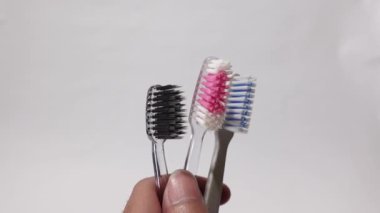 Beyaz arka planda üç farklı renkte diş fırçası var.