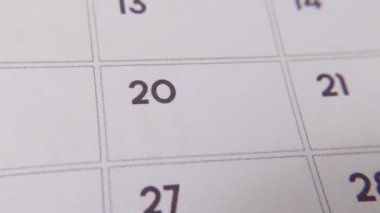 Takvimin 20. yılı kırmızı kalemle işaretlenmiştir. Beyaz bir sayfadaki yakın çekim, önemli bir günü ya da hatırlatmayı sembolize eder..