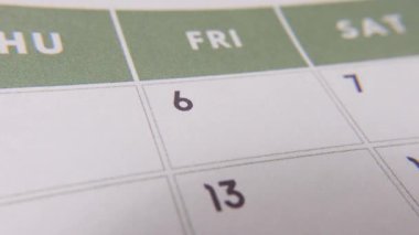 6 numaralı tarih işaretleniyor, takvime kırmızı haçla vurgulanan sayıya odaklanıyor. Teslim tarihlerini, hatırlatıcıları, planlamaları ve zaman yönetimini temsil eder