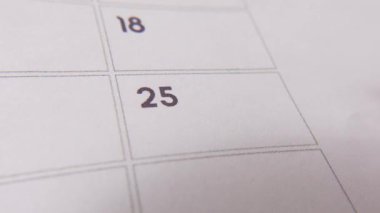 25 numaralı tarih işaretleniyor, takvimde kırmızı haçla vurgulanan sayıya odaklanıyor. Teslim tarihlerini, hatırlatıcıları, planlamaları ve zaman yönetimini temsil eder