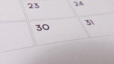 30 numaralı tarih işaretleniyor, takvimde kırmızı haçla vurgulanan sayıya odaklanıyor. Teslim tarihlerini, hatırlatıcıları, planlamaları ve zaman yönetimini temsil eder