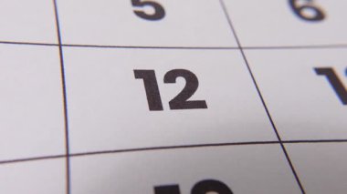 Önemli bir hatırlatma veya planlanmış olayı vurgulayan koyu kırmızı haç işaretli bir takvimdeki 12 numaralı tarihi vurgula.
