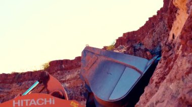 Büyük yükleyici kovasını kırmızı kil ile doldurur ve sonra empatiyle doldurur. 4k.