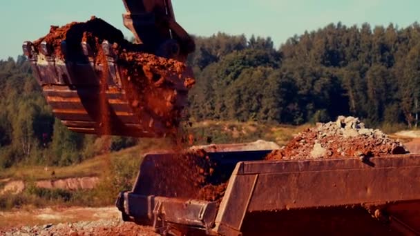 掘削機は 早朝に 粘土採石場で ダンプトラックに粘土をロードしています 25パーセクスローモーション — ストック動画