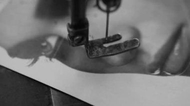 Birinin eski moda dikiş makinesiyle dergi sayfasını deldiği siyah beyaz bir video. Video sanat projeleri için iyi görüntüler.