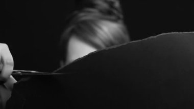 Siyah kağıdı makasla kesen bir kadının siyah beyaz videosu. Sanat, sanatsal, gizli kadın yüzü, gözler. Müzik videosu için iyi. Yakın plan..