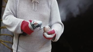 Sanatçı taşları öğütücüyle kesiyor. Elle tutulan bir sanatçının elindeki taşı öğüttüğü fotoğraf makinesi..